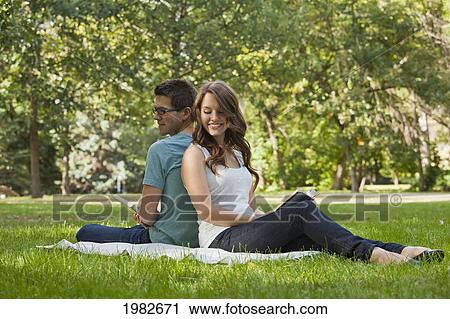 Stock Image - newlywed couple reading together in a park; edmonton alberta canada. Fotosearch