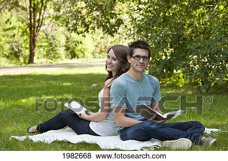 newlywed couple reading together in a park; edmonton alberta canada View Large Photo Image Stock Photo - newlywed couple reading together in a park; edmonton alberta canada. Fotosearch