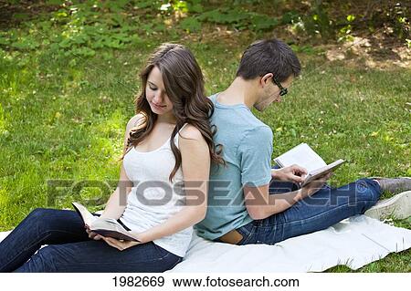 newlywed couple reading together in a park; edmonton alberta canada View Large Photo Image Stock Photo - newlywed couple reading together in a park; edmonton alberta canada. Fotosearch