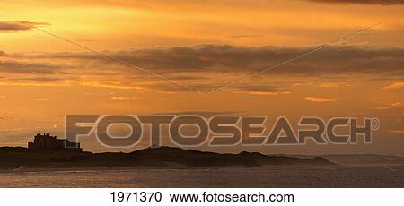 orange glow over the water at sunset with a silhouette of bamburgh castle; northumberland england View Large Photo Image Stock Image - orange glow over the water at sunset with a silhouette of bamburgh castle; northumberland england. Fotosearch