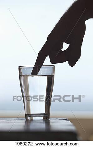 outstretched finger of silhouetted hand touching surface of water in glass; spain View Large Photo Image Stock Image - outstretched finger of silhouetted hand touching surface of water in glass; spain. Fotosearch
