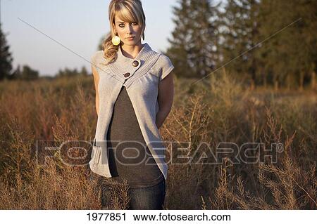 portrait of a young woman standing in a field; edmonton alberta canada View Large Photo Image Stock Image - portrait of a young woman standing in a field; edmonton alberta canada. Fotosearch