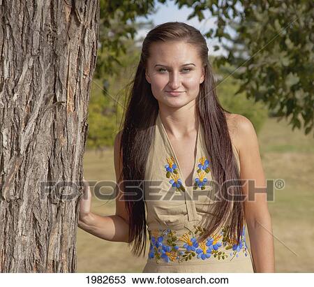 Stock Image - portrait of a young woman with long hair in a park; edmonton alberta canada. Fotosearch