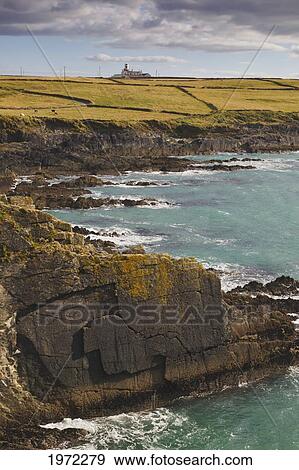 rock ledges along the coastline at galley head with a lighthouse in the background; county cork ireland View Large Photo Image Stock Photo - rock ledges along the coastline at galley head with a lighthouse in the background; county cork ireland. Fotosearch