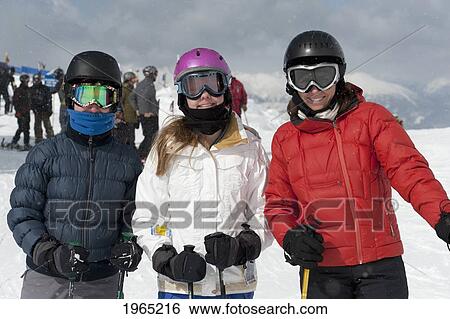 Stock Photograph - skiers pose with mountains in the background; whistler british columbia canada. Fotosearch
