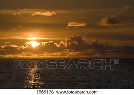 sun setting on the ocean with the sunlight reflecting on the water; lincoln city oregon united states of america View Large Photo Image Stock Photo - sun setting on the ocean with the sunlight reflecting on the water; lincoln city oregon united states of america. Fotosearch