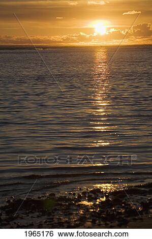 sun setting on the ocean with the sunlight reflecting on the water; lincoln city oregon united states of america View Large Photo Image Stock Photograph - sun setting on the ocean with the sunlight reflecting on the water; lincoln city oregon united states of america. Fotosearch