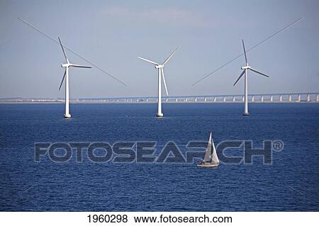 Stock Photo - three wind turbines and a sailboat in the water; copenhagen, denmark. Fotosearch