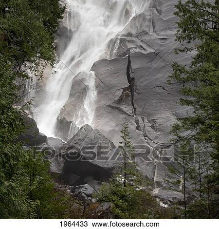 Stock Image - water cascading down the rock and forming a mist in jasper national park; alberta, canada. Fotosearch