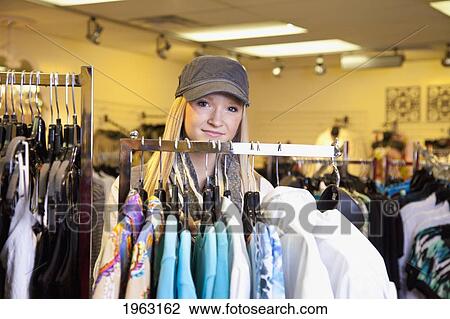 Stock Image - young woman shopping for clothing at a boutique; edmonton, alberta, canada. Fotosearch