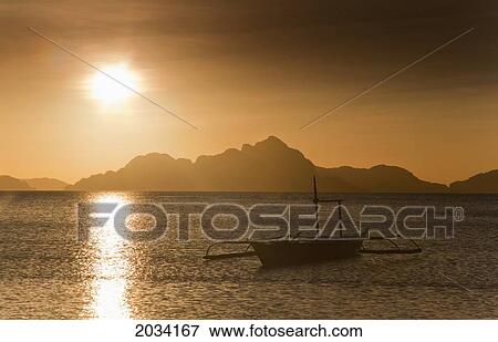 A Boat Is Silhouetted In The Water At Sunset; Corong Corong Bacuit Archipelago Palawan Philippines View Large Photo Image Stock Photo - A Boat Is Silhouetted In The Water At Sunset; Corong Corong Bacuit Archipelago Palawan Philippines. Fotosearch