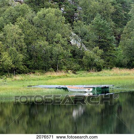 A boat moored beside a dock in tranquil water; hardangervidda norway View Large Photo Image Stock Image - A boat moored beside a dock in tranquil water; hardangervidda norway. Fotosearch
