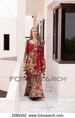 A bride in an ornate red and gold gown walking down a corridor; ludhiana punjab india View Large Photo Image Stock Image - A bride in an ornate red and gold gown walking down a corridor; ludhiana punjab india. Fotosearch