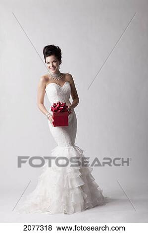 A bride posing with a red gift against a white background; nashville tennessee united states of america View Large Photo Image Stock Photo - A bride posing with a red gift against a white background; nashville tennessee united states of america. Fotosearch