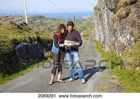 A Couple Standing On A Road Reading A Map Near Ardgroom; County Cork Ireland View Large Photo Image Stock Image - A Couple Standing On A Road Reading A Map Near Ardgroom; County Cork Ireland. Fotosearch