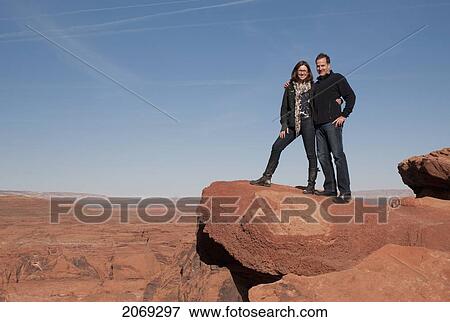 Stock Photo - A Couple Stands On A Sandstone Ledge; Arizona United States Of America. Fotosearch