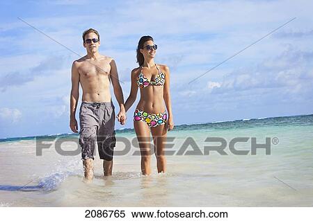 A couple walking in the shallow water along the beach holding hands; punta cana la altagracia dominican republic View Large Photo Image Stock Photography - A couple walking in the shallow water along the beach holding hands; punta cana la altagracia dominican republic. Fotosearch