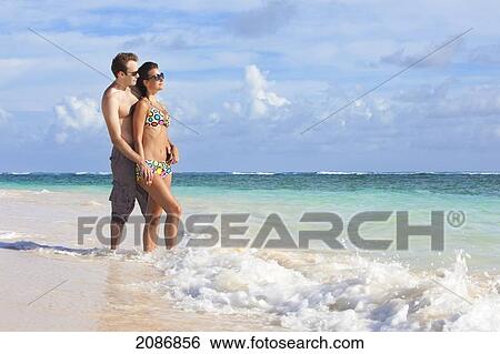 A couple wearing swimsuits stand in the ocean holding hands; punta cana la altagracia dominican republic View Large Photo Image Stock Photograph - A couple wearing swimsuits stand in the ocean holding hands; punta cana la altagracia dominican republic. Fotosearch
