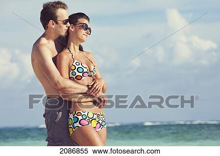 A couple wearing swimsuits stand in the ocean in an embrace; punta cana la altagracia dominican republic View Large Photo Image Stock Photography - A couple wearing swimsuits stand in the ocean in an embrace; punta cana la altagracia dominican republic. Fotosearch