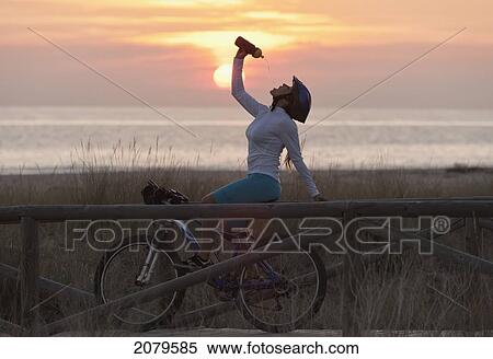 A cyclist stops for a drink on a wooden boardwalk along the ocean; tarifa cadiz andalusia spain View Large Photo Image Stock Photography - A cyclist stops for a drink on a wooden boardwalk along the ocean; tarifa cadiz andalusia spain. Fotosearch