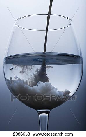 A dark cloudy liquid being poured into a water glass; tarifa cadiz andalusia spain View Large Photo Image Stock Photo - A dark cloudy liquid being poured into a water glass; tarifa cadiz andalusia spain. Fotosearch