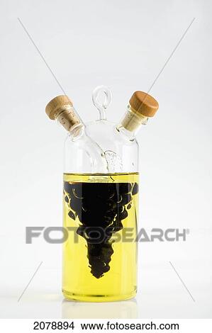 A Decorative Glass Bottle Filled With Balsamic Vinegar In A Grape