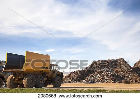 A dump truck sitting beside a pile of debris; south shields tyne and wear england View Large Photo Image Stock Photo - A dump truck sitting beside a pile of debris; south shields tyne and wear england. Fotosearch
