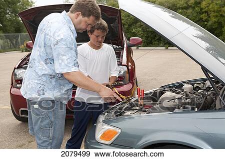 A father and son work together to boost a car battery; edmonton alberta canada View Large Photo Image Stock Photo - A father and son work together to boost a car battery; edmonton alberta canada. Fotosearch