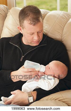 Stock Image - A Father Feeding His Newborn Baby From A Bottle; Dundas Minnesota United States Of America. Fotosearch