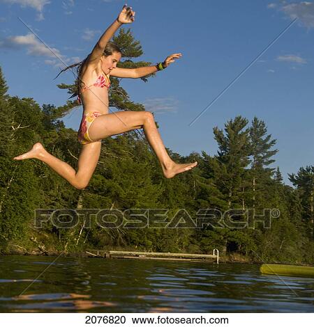 A girl jumping into the lake; lake of the woods ontario canada View Large Photo Image Stock Image - A girl jumping into the lake; lake of the woods ontario canada. Fotosearch