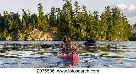 A girl kayaking in the lake; lake of the woods ontario canada View Large Photo Image Stock Photograph - A girl kayaking in the lake; lake of the woods ontario canada. Fotosearch