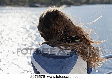 A girl's hair blowing in the wind as she stands at a railing on the water's edge; norway View Large Photo Image Stock Photo - A girl's hair blowing in the wind as she stands at a railing on the water's edge; norway. Fotosearch