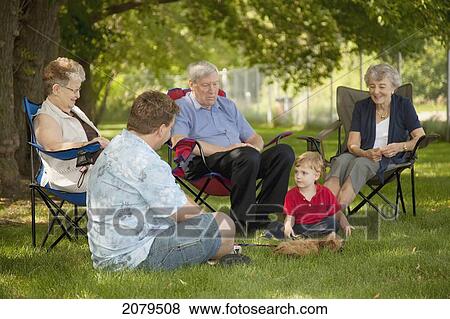 Stock Photo - A group of people sit on the lawn visiting; edmonton alberta canada. Fotosearch
