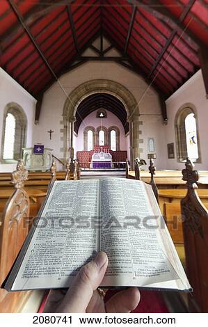 A hand holds a small open bible at the back of a church; howick northumberland england View Large Photo Image Stock Image - A hand holds a small open bible at the back of a church; howick northumberland england. Fotosearch