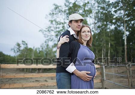 A husband embraces his wife and her pregnant belly; sherwood park alberta canada View Large Photo Image Stock Image - A husband embraces his wife and her pregnant belly; sherwood park alberta canada. Fotosearch