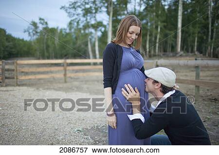 A husband kissing his wife's pregnant belly; sherwood park alberta canada View Large Photo Image Stock Photo - A husband kissing his wife's pregnant belly; sherwood park alberta canada. Fotosearch