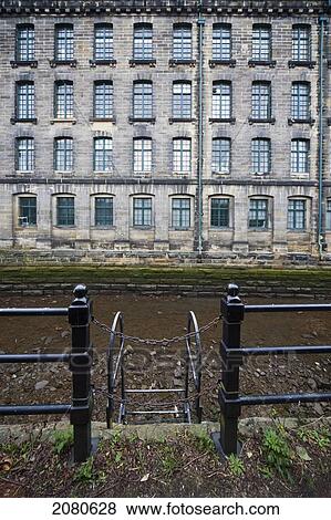 Stock Photo - A ladder chained off on a black railing and a building with rows of windows; newcastle northumberland england. Fotosearch