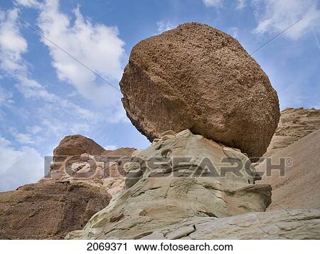 Stock Image - A Large Boulder Resting On A Rock Formation On Rugged Terrain; Utah United States Of America. Fotosearch