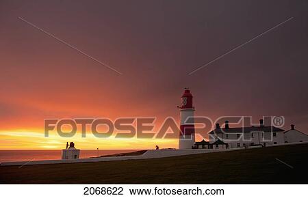 Stock Image - A Lighthouse On The Coast At Sunset; Whitburn Tyne And Wear England. Fotosearch
