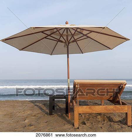 A lounge chair and umbrella on the beach at the water's edge; sayulita mexico View Large Photo Image Stock Image - A lounge chair and umbrella on the beach at the water's edge; sayulita mexico. Fotosearch