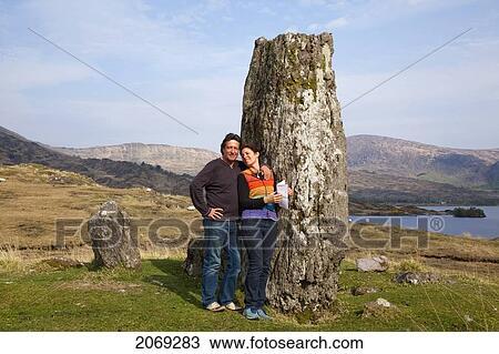 A Man And Woman Pose In Front Of A Rock Formation Along The Coast Near Kenmare; County Kerry Ireland View Large Photo Image Stock Image - A Man And Woman Pose In Front Of A Rock Formation Along The Coast Near Kenmare; County Kerry Ireland. Fotosearch