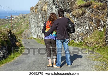 Stock Photo - A Man And Woman Stand Looking At The View Of The Ocean Near Argroom; County Cork Ireland. Fotosearch