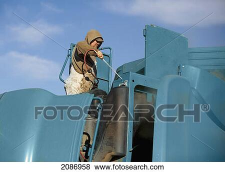 A man cleaning farm equipment; three hills alberta canada View Large Photo Image Stock Photo - A man cleaning farm equipment; three hills alberta canada. Fotosearch