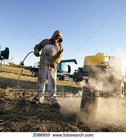 A man cleaning farm equipment; three hills alberta canada View Large Photo Image Stock Photo - A man cleaning farm equipment; three hills alberta canada. Fotosearch