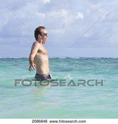 A man entering the cold ocean water with a shocked look on his face; punta cana la altagracia dominican republic View Large Photo Image Stock Photo - A man entering the cold ocean water with a shocked look on his face; punta cana la altagracia dominican republic. Fotosearch