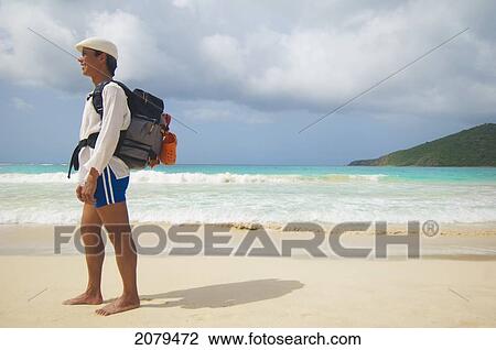 A man wearing a backpack stands on a beach; puerto rico View Large Photo Image Stock Image - A man wearing a backpack stands on a beach; puerto rico. Fotosearch