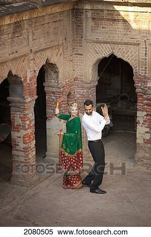 A mixed race couple dancing in a courtyard with her wearing a sari; ludhiana punjab india View Large Photo Image Stock Photography - A mixed race couple dancing in a courtyard with her wearing a sari; ludhiana punjab india. Fotosearch