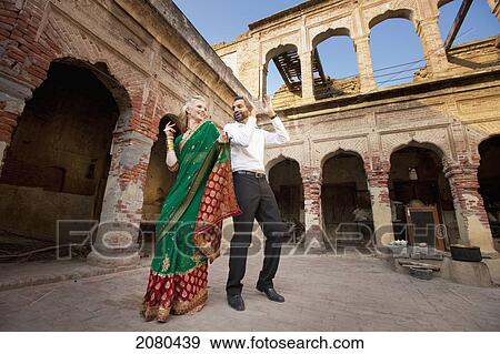 Stock Photo - A mixed race couple dancing with her wearing a sari; ludhiana punjab india. Fotosearch