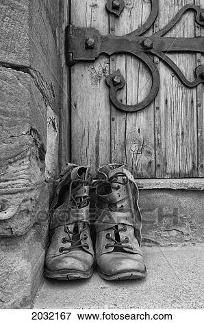 Stock Photo - A Park Of Worn Boots Outside A Door; Northumberland England. Fotosearch