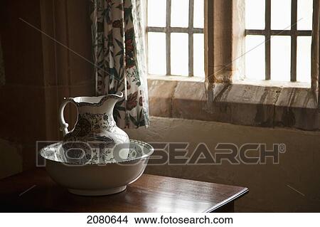 Picture - A pitcher and basin sit on the table beside a window; lindisfarne northumberland england. Fotosearch